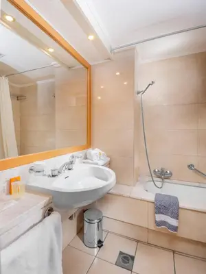 a bathroom with a sink and a shower at Athineon Hotel in Rhodes Town