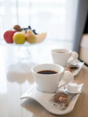 two cups of coffee on a plate with a pastry at Athineon Hotel in Rhodes Town