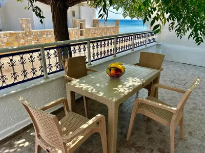 a table and chairs with a bowl of fruit on it at Stella Beach House in Archangelos