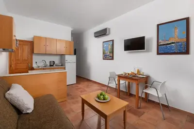 a living room and kitchen with a couch and a table at George's Villas in Líndos
