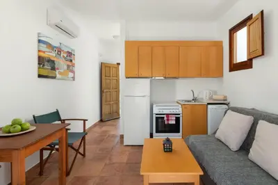 a kitchen and a living room with a couch and a table at George's Villas in Líndos
