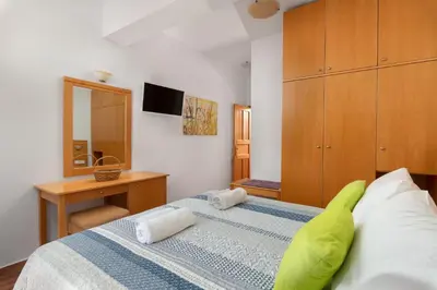 a bedroom with a bed with a green pillow on it at George's Villas in Líndos