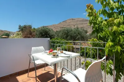 a white table and chairs on a balcony at George's Villas in Líndos