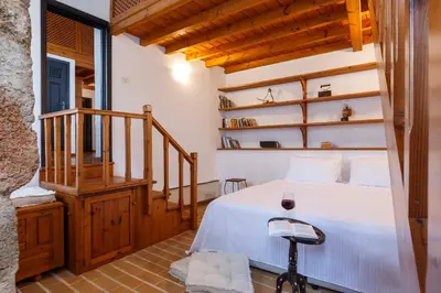 a bedroom with a white bed and a staircase at Belvedere Medieval Villa in Rhodes Town