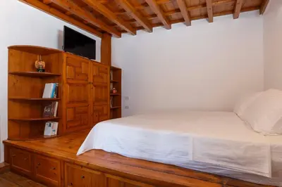 a bedroom with a bed and a tv on a wooden cabinet at Belvedere Medieval Villa in Rhodes Town