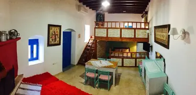 a room with a table and chairs and a fireplace at Mariza's traditional house 1900 in Soroni