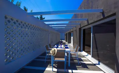 a row of tables and chairs on a balcony at Villa Elpiniki in Ixia