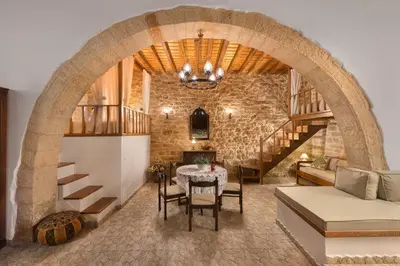 a living room with a table and a brick wall at Rodia House in Lardos