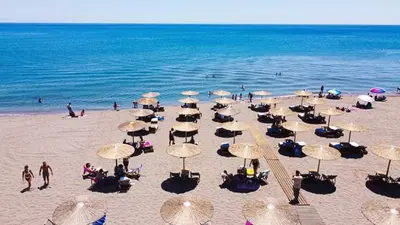a beach with many umbrellas and people on the beach at Sotiris rooms in Faliraki