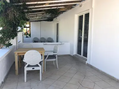 a patio with a wooden table and chairs on a porch at Sotiris rooms in Faliraki