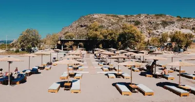 a bunch of chairs and umbrellas on a beach at Sotiris rooms in Faliraki