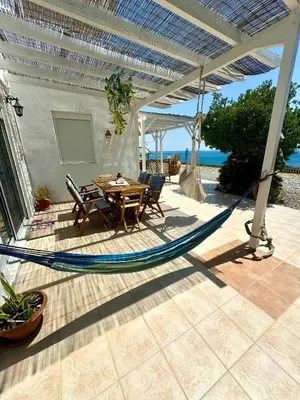 a hammock on a patio with a table and chairs at Sea House Lahania in Lachania