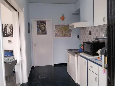 a kitchen with white cabinets and a black floor at Apollon Apartments H-3 H-4 in Rhodes Town