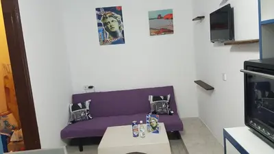a living room with a purple couch and a table at Apollon Apartments H-3 H-4 in Rhodes Town
