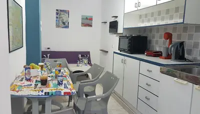 a kitchen with a table with chairs and a sink at Apollon Apartments H-3 H-4 in Rhodes Town