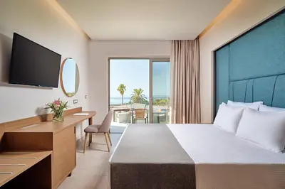 a hotel room with a bed and a desk and a window at Princess Sun Hotel in Kiotari