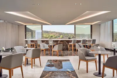a restaurant with tables and chairs and large windows at Princess Sun Hotel in Kiotari
