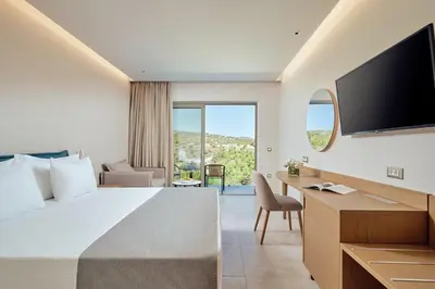 a hotel room with a bed and a flat screen tv at Princess Sun Hotel in Kiotari