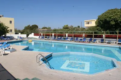 a large swimming pool with blue lounge chairs at Summer Dream in Theologos