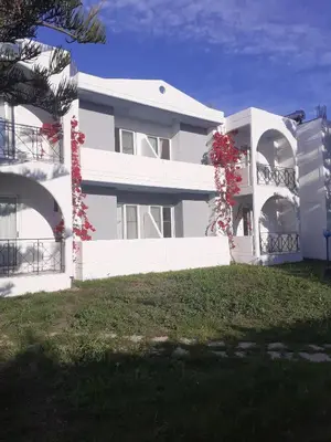 a white building with red flowers in front of it at Summer Dream in Theologos