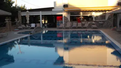 a pool with chairs and a table and a building at Panorama Studios in Faliraki