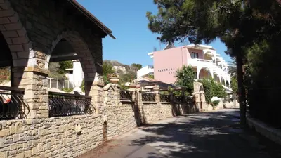 a street in a village with a stone wall at Panorama Studios in Faliraki