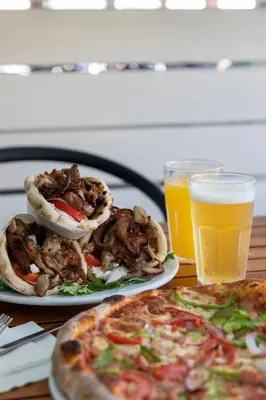 a table with two plates of food and two glasses of beer at Sol Cosmopolitan Rhodes in Ixia
