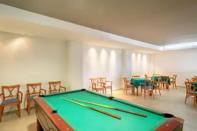 a pool table in a room with tables and chairs at Sol Cosmopolitan Rhodes in Ixia
