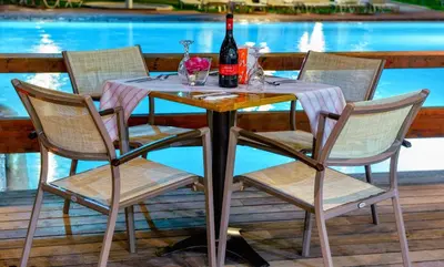 a table with three chairs and a bottle of wine at Sol Cosmopolitan Rhodes in Ixia