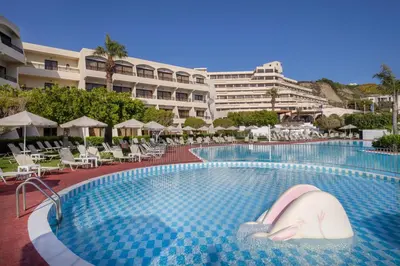 a swimming pool at a hotel with chairs and umbrellas at Sol Cosmopolitan Rhodes in Ixia