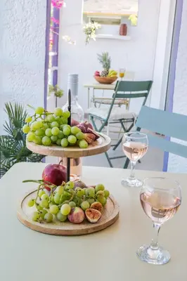 a table with two plates of grapes and wine glasses at Rosmari Hotel in Archangelos