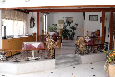 a living room with a table and chairs at Rosmari Hotel in Archangelos