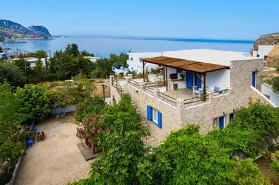an aerial view of a house with the ocean in the background at Agnanti Beach Apartments in Archangelos