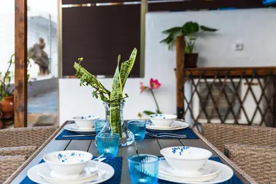 a table with plates and bowls and a vase at Agnanti Beach Apartments in Archangelos