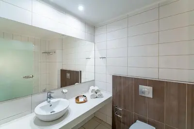 a white bathroom with a sink and a mirror at Cathrin Hotel in Faliraki