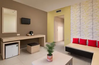 a living room with a couch and red pillows at Virginia Family Resort in Kallithea Rhodes