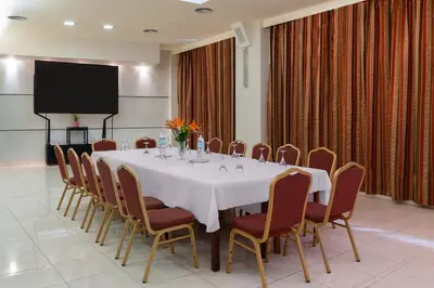 a conference room with a table and chairs and a screen at Virginia Family Resort in Kallithea Rhodes