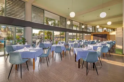 a restaurant with blue and white tables and chairs at Virginia Family Resort in Kallithea Rhodes
