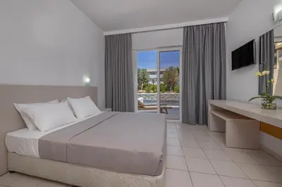 a bedroom with a bed and a view of a pool at Virginia Family Resort in Kallithea Rhodes
