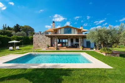 a villa with a swimming pool in front of a house at Blue & Green View Villa in Asgourou