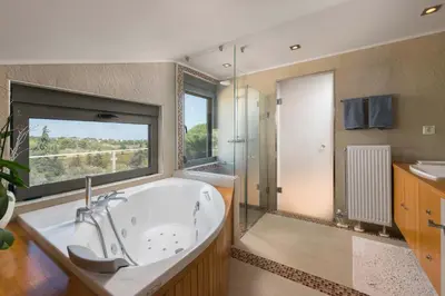a large bathroom with a tub and a window at Blue & Green View Villa in Asgourou