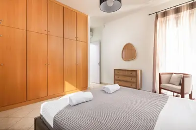 a bedroom with a bed with wooden cabinets and a chair at Blue & Green View Villa in Asgourou