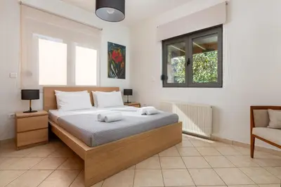 a bedroom with a bed with two towels on it at Blue & Green View Villa in Asgourou