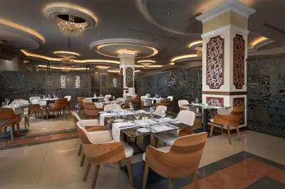 a dining room with white tables and chairs at La Marquise Luxury Resort Complex in Faliraki