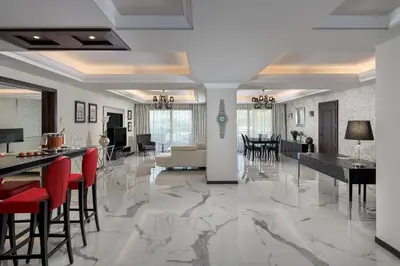 a living room with a marble floor and red chairs at La Marquise Luxury Resort Complex in Faliraki