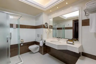 a bathroom with a sink and a toilet and a mirror at La Marquise Luxury Resort Complex in Faliraki