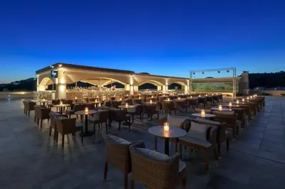 a restaurant with tables and chairs at night at La Marquise Luxury Resort Complex in Faliraki