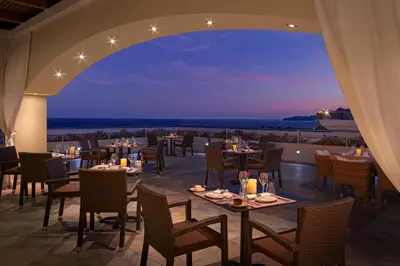 a restaurant with tables and chairs and a view of the ocean at La Marquise Luxury Resort Complex in Faliraki