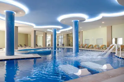 a pool in a hotel with blue columns and a water slide at Atrium Platinum Resort & Spa in Ixia