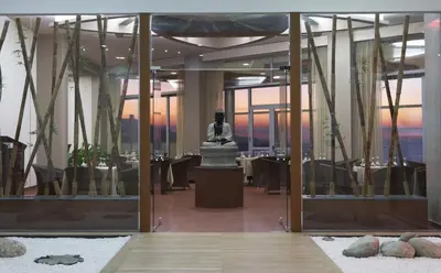a statue in the middle of a room with tables at Atrium Platinum Resort & Spa in Ixia